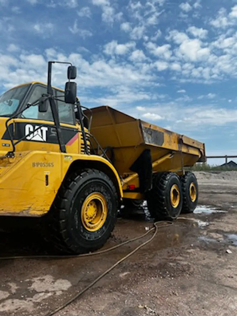 A hot-water rinse on an articulated haul truck
